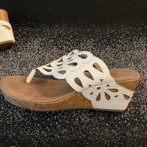 Laser cutout wedge sandals.